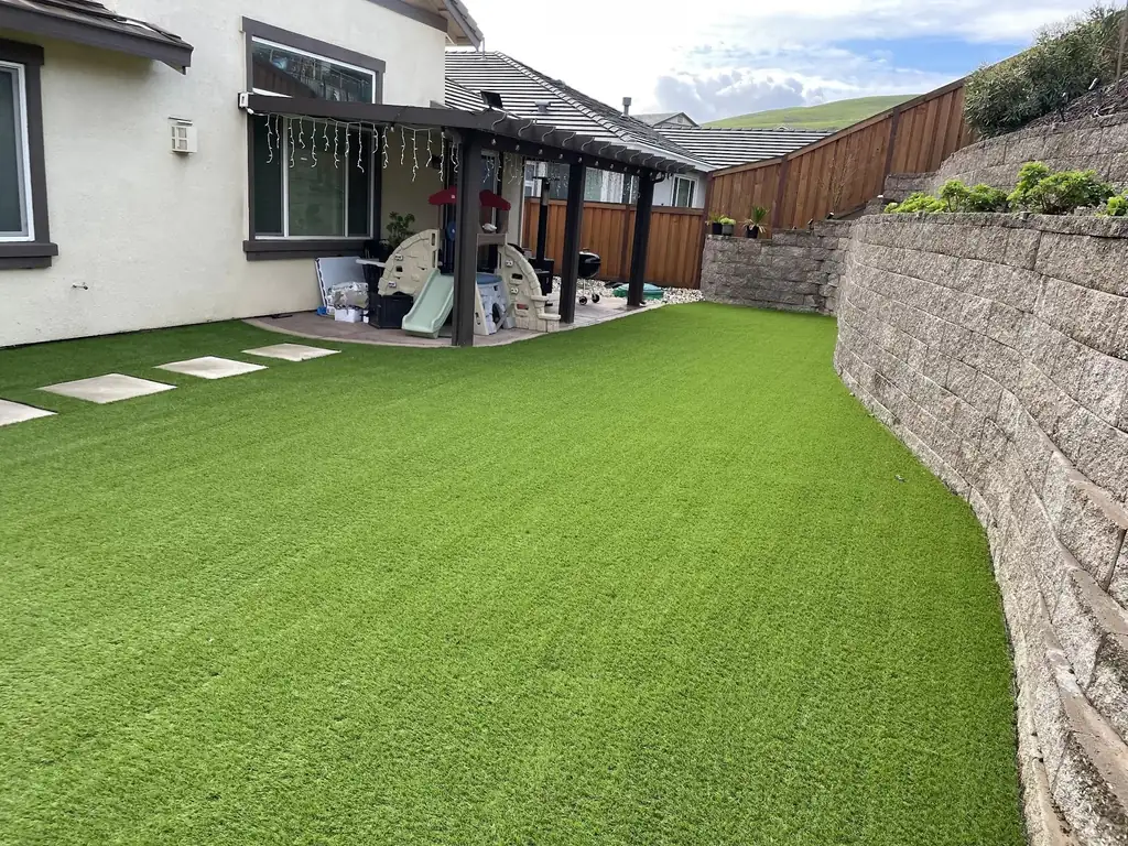 Backyard with artificial grass beside a patio